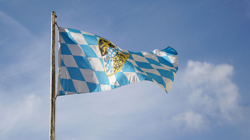 Bayern: Bayerische Flagge vor blauem Himmel
