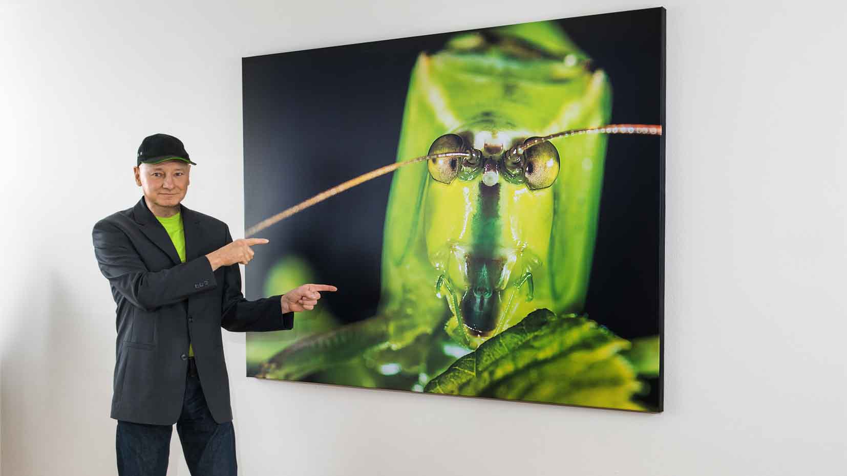 Maximilian Weinzierl vor einer großformatigen Fotografie seiner Ausstellung "NAH"