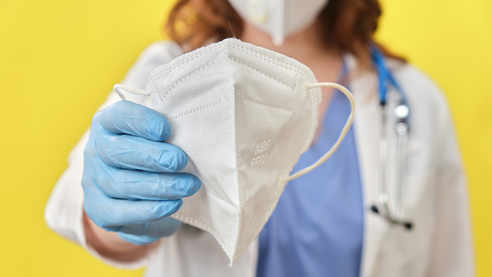 Ärztin mit Maske in der Hand