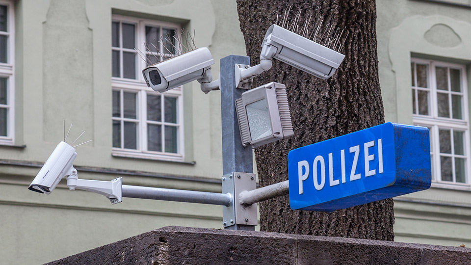 Überwachungskameras der Polizei und ein blaues Schild mit der Aufschrift "POLIZEI".