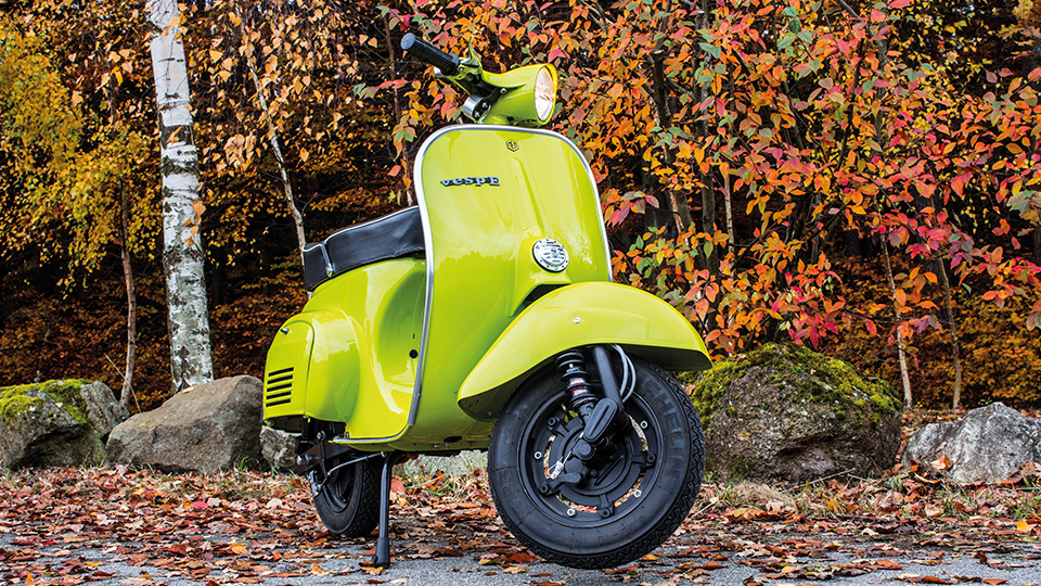 E-Rollre VespE V50 MEM_Motors in hellgrün von vorne vor herbstlichem Hintergrund.