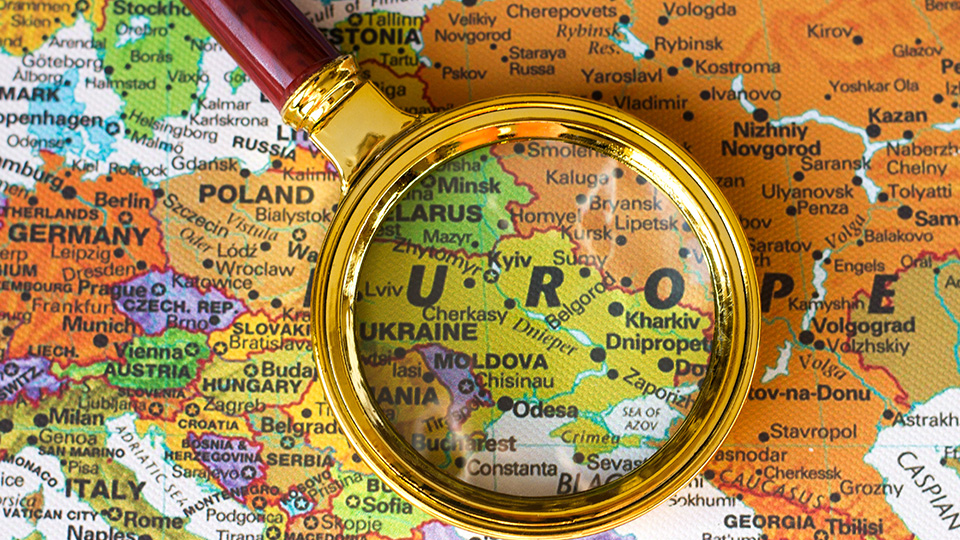 Landkarte, die einen Teil Europas zeigt mit einer Lupe, die unter anderem die Ukraine vergrößert darstellt.