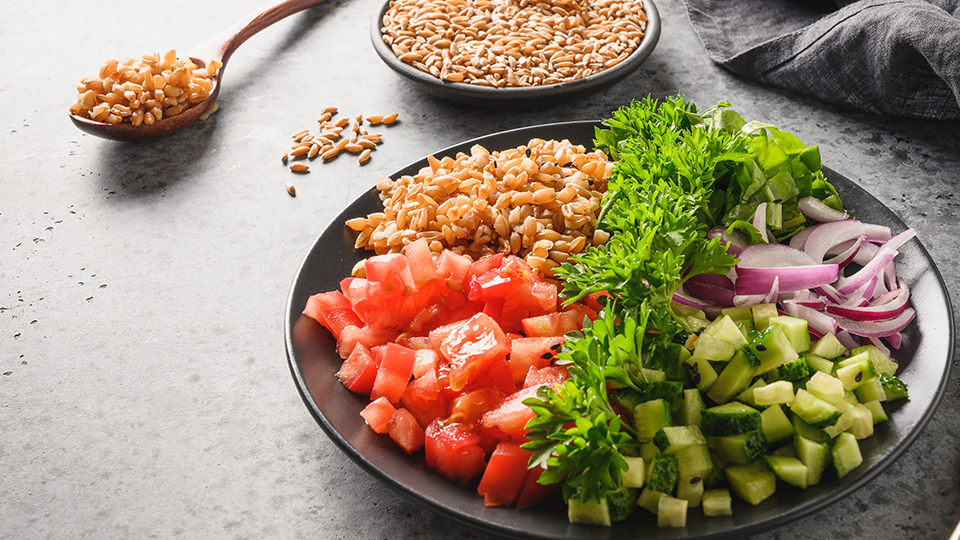 Ein typischer Teller für eine Diät: Mit Tomaten, Gurken, Zwiebeln, frischen Kräutern und Vollkorngetreide.