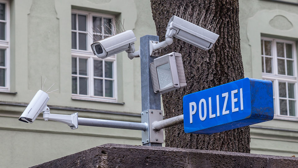 Polizei Schild in Blau-Weiß und Überwachungskameras.