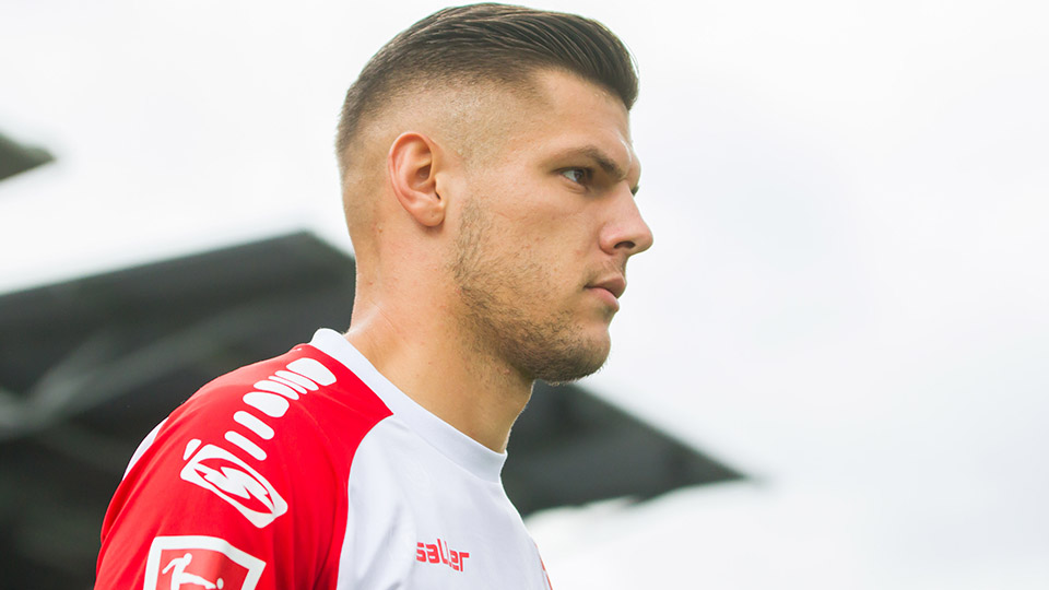 Erik Wekesser vom SSV Jahn Regensburg von der Seite in seinem weiß-roten Fußball-Trikot.