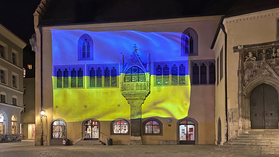 Das alte Rathaus in Regensburg mit einer Projektion der Ukraine-Flagge.