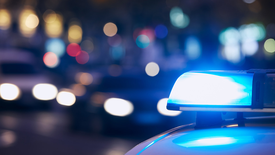 Blaulicht eines Streifenwagens der Polizei im Dunkeln.