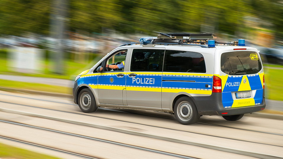 Streifenwagen der Polizei während der Fahrt von der Seite.