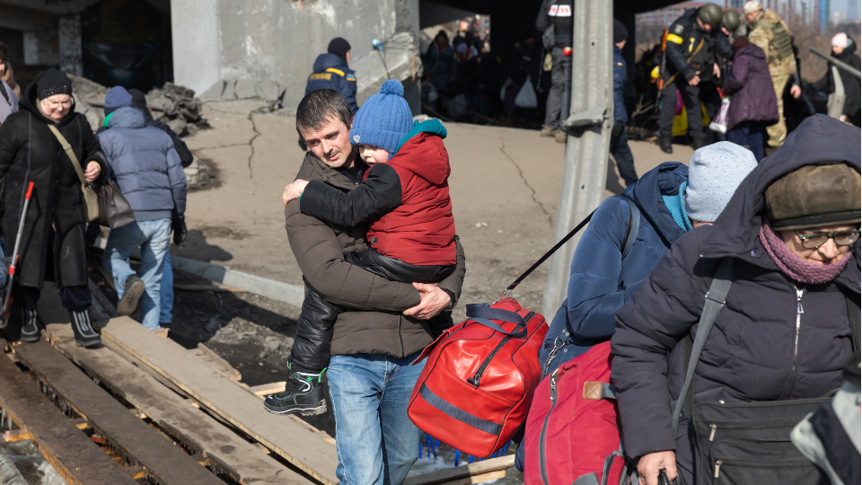 Flüchtende Ukrainer vor einer zerstörten Brücke