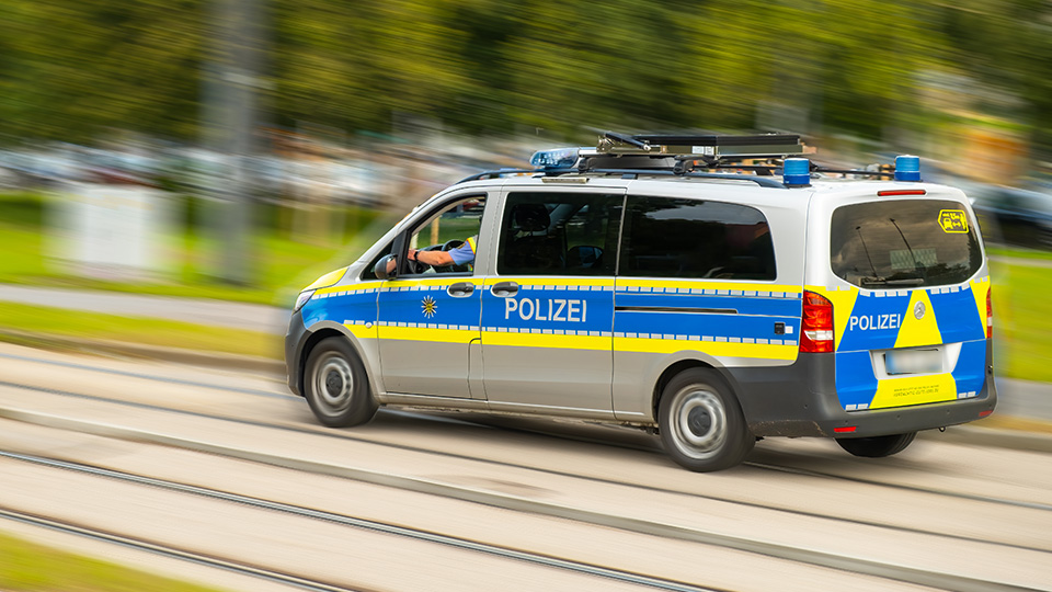 Streifenwagen der Polizei während der Fahrt von der Seite.