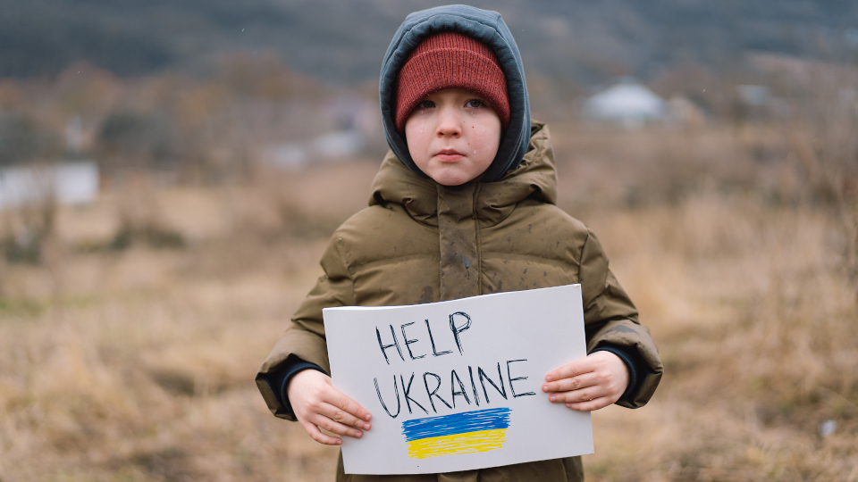 Kleiner Junge hält ein Schild mit Help Ukraine