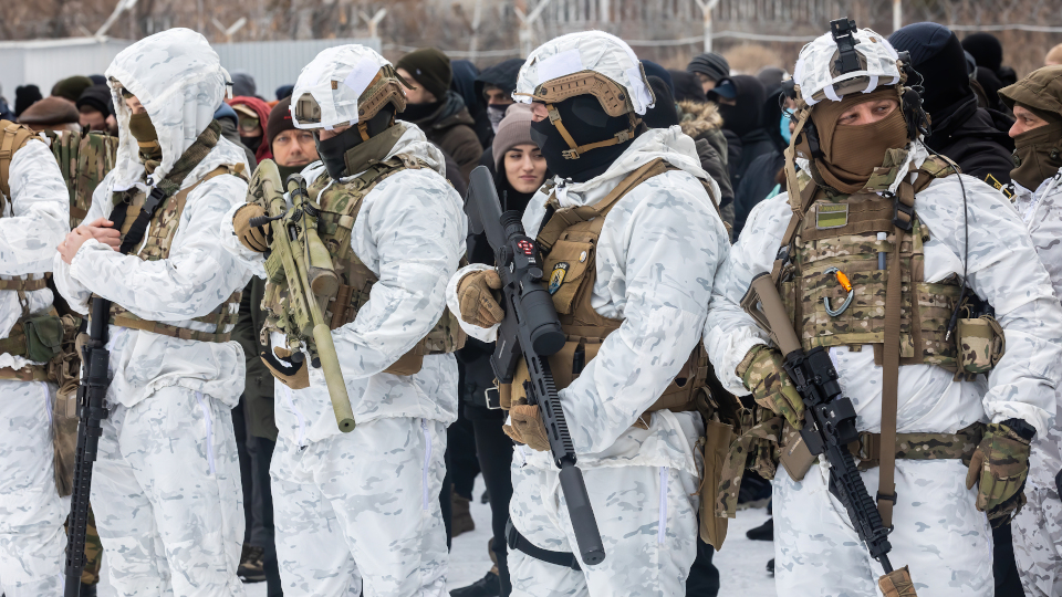 Ukrainische Soldaten vor einer Reihe von Zivilisten