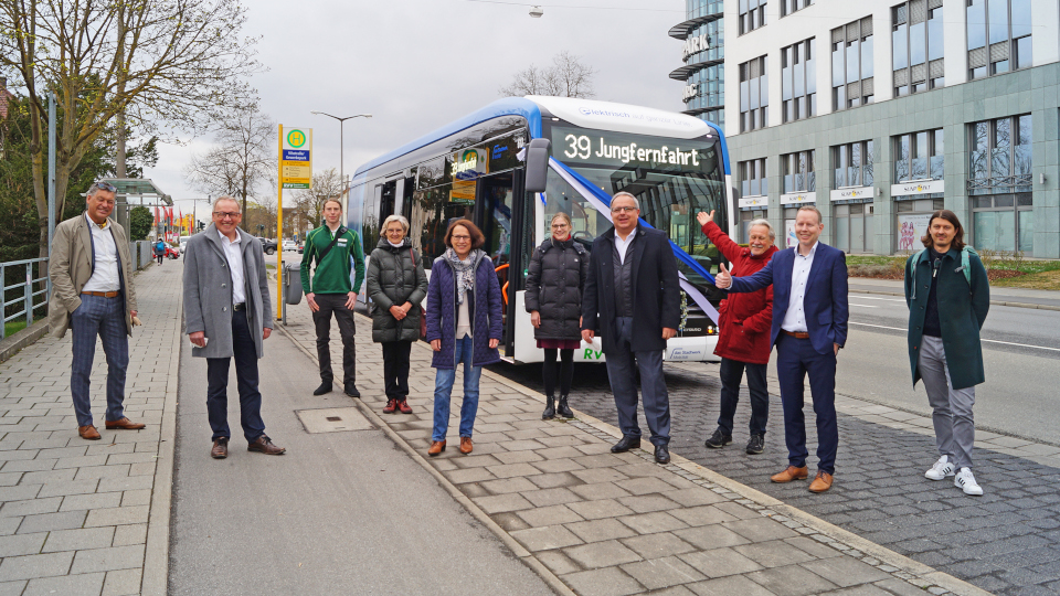 Verschiedene Fahrgäste um die Oberbürgermeisterin bei der Jungfahnfahrt der neuen Buslinie