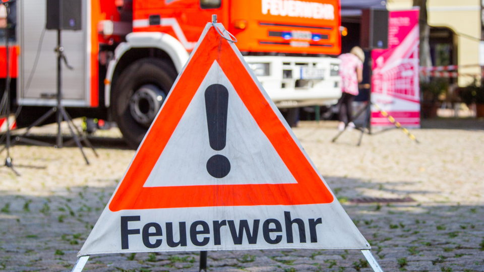 Feuerwehrwarndreieck vor Einsatzfahrzeugen