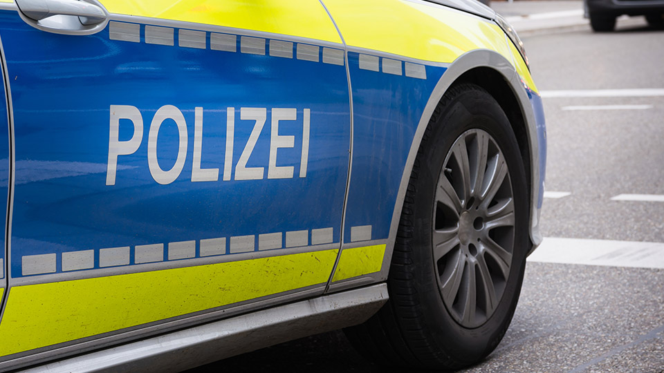 Streifenwagen der Polizei von der Seite, der Schriftzug "POLIZEI" ist dabei im Vordergrund.