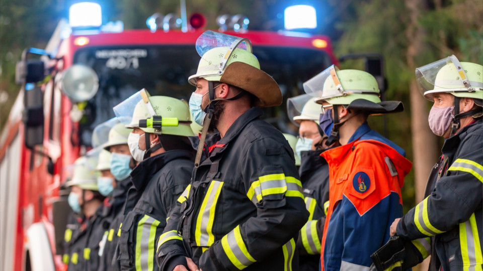 Feuerwehrleute vor Einsatzfahrzeug