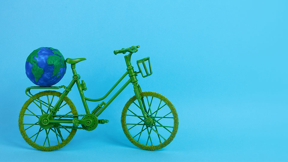 Verkehrsstörungen am internationaler Tag des Fahrrads: Grünes Fahrrad mit Weltkugel vor blauem Hintergrund.