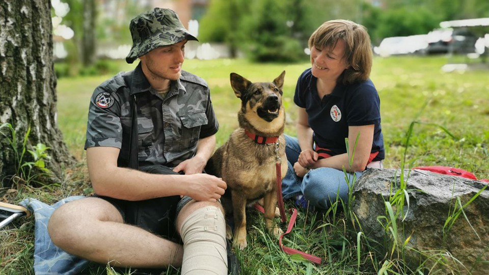 Streunerhündin Busia hilft verwundeten Soldatinnen und Soldaten. Hier mit einem Soldaten und einer Pflegerin.