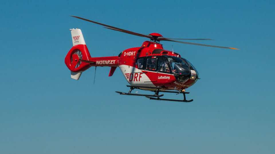 Rettungshubschrauber in weiß-rot auf einem Einsatzflug.