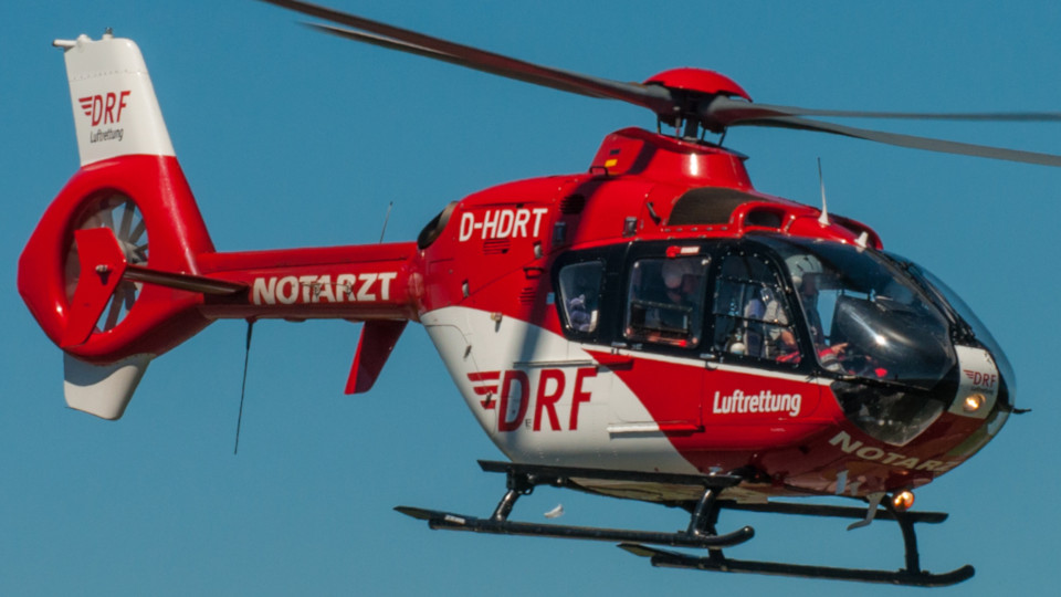 Rettungshubschrauber in weiß-rot auf einem Einsatzflug.