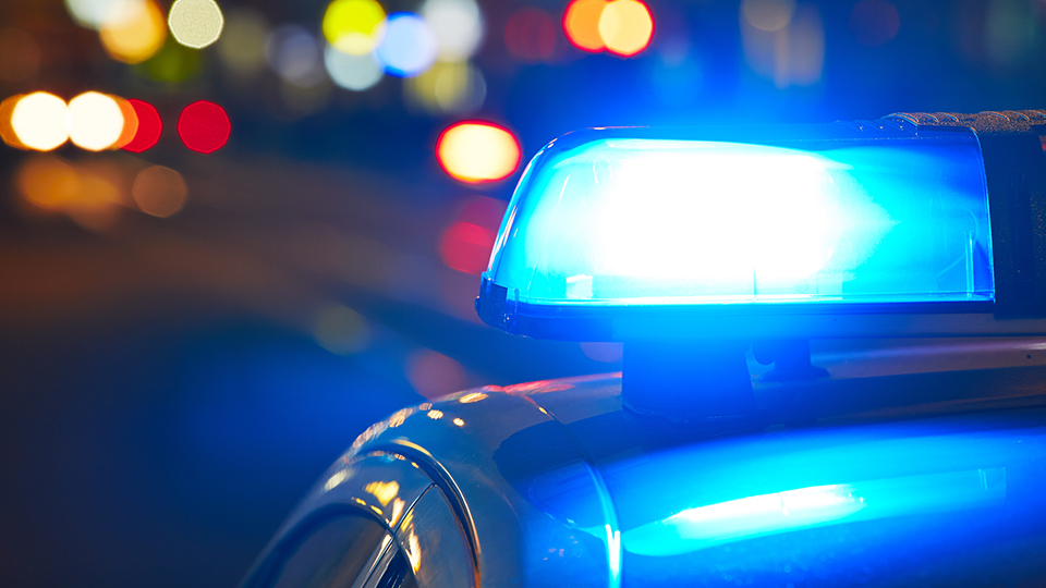 Streifenwagen der Polizei mit Blaulicht in der Nacht.