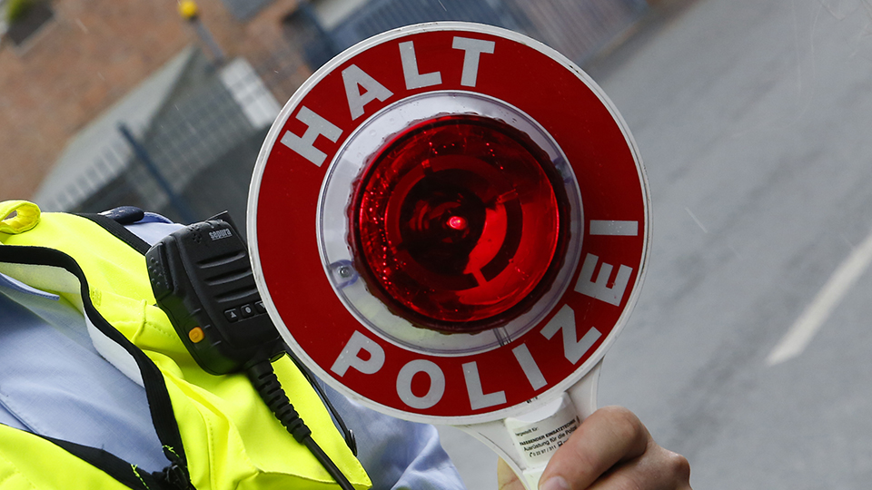 Beamter mit einem "Halt! Polizei!" Schild