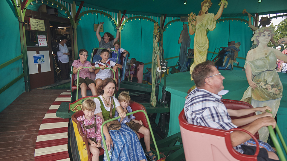 Eltern mit ihren Kindern im historischen Bereich des Gäubodenvolksfestes in Straubing.