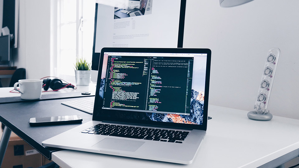 Digitale Kompetenzen: Aufgeklappter Laptop auf einem Schreibtisch.