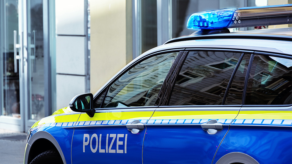 Streifenwagen der Polizei vor Gebäude.