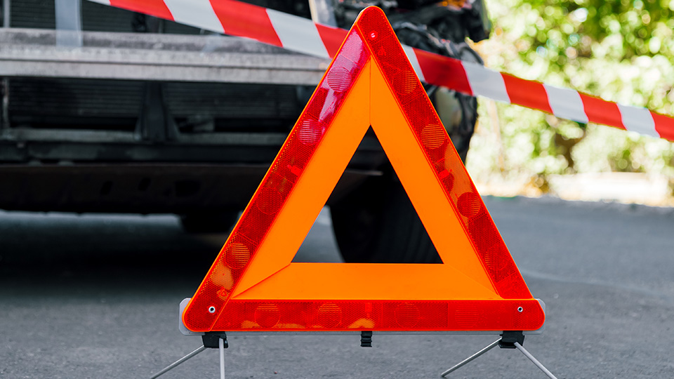 Krankenwagen bei Einsatzfahrt verunglückt: Symbolfoto eines Warndreiecks vor Absperrband