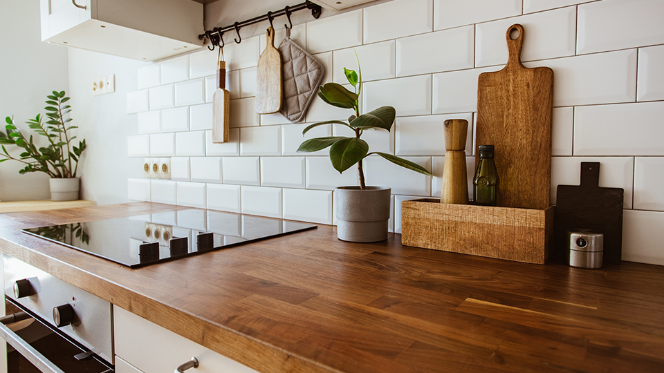 Kleine Küche mit Arbeitsfläche aus Holz und einigen Küchenutensilien sowie einer Hängeleiste.