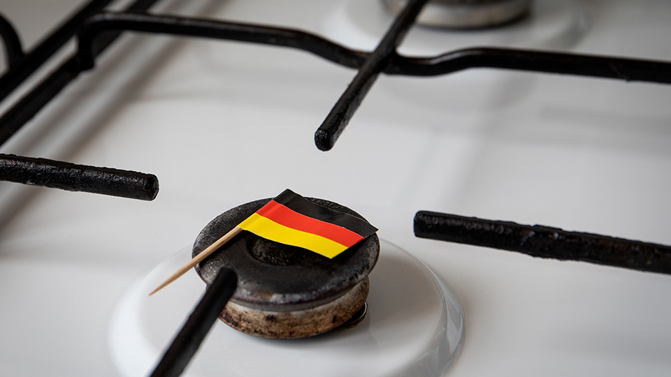 Entlastungspaket der Bundesregierung: Gasherd, auf dem eine deutsche Flagge liegt.