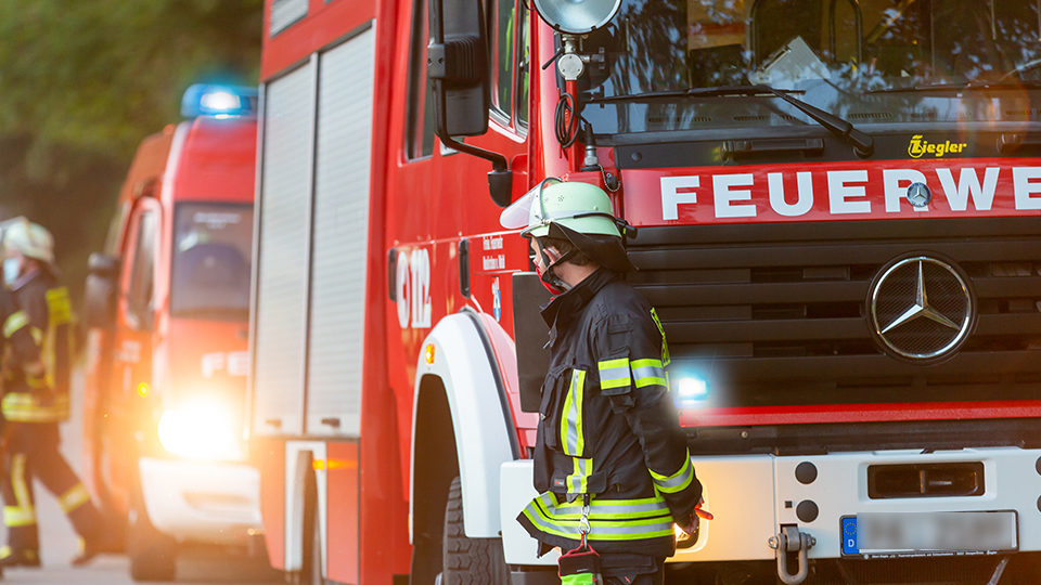 Unbekannter legt Feuer: Feuerwehrfahrzeuge und Feuerwehrleute