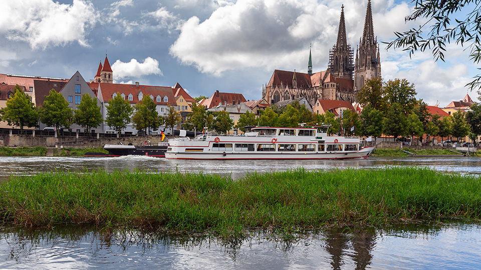 Regensburg mit der Donau im Vordergrund und dem Dom und der Stadtkulisse im Hintergrund