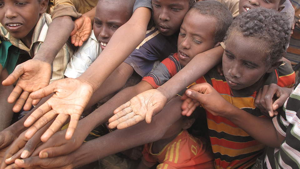 Globale Ernährungskrise: Kinder aus Afrika, die die Hände aufhalten, um Essen zu bekommen.