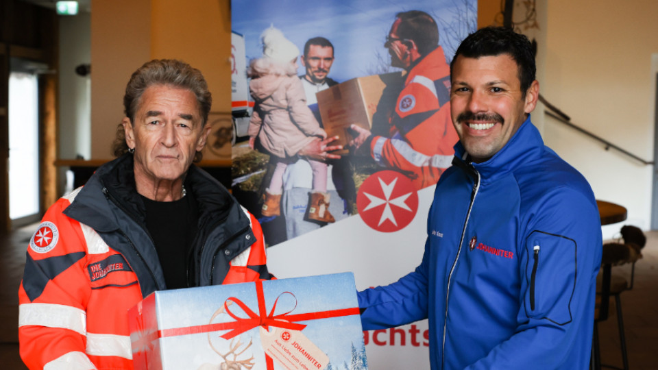 Peter Maffay übergibt an Ulrich Kraus, Projektleiter Johanniter-Weihnachtstrucker, sein Paket