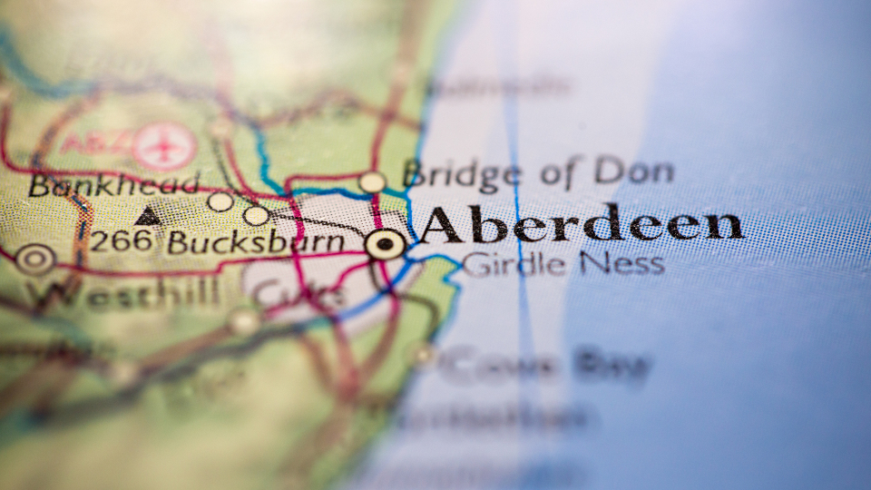 Shallow depth of field focus on geographical map location of Aberdeen city England United Kingdom Great Britain Europe continent on atlas