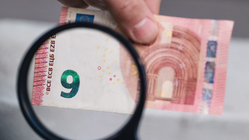 10 Euroschein unter der Lupe, der sich als 9 Euroschein entpuppt