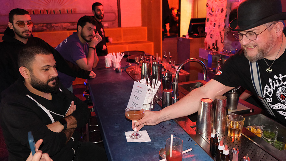 Bartender in Beirut gibt seinen Gästen lächelnd einen Blutwurz-Cocktail