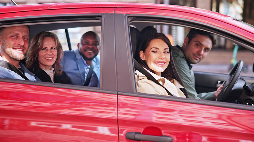 Fahrgemeinschaft: Fünf Leute in rotem Auto