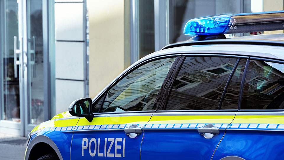 Streifenwagen der Polizei vor Justizgebäude