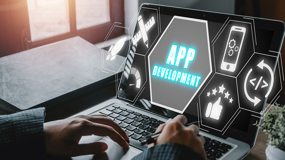 Karriere in IT-Branche: Geöffneter Laptop, auf dem App Development, zu Deutsch App Entwicklung steht.
