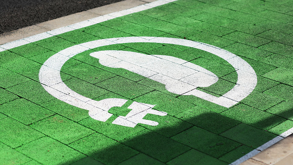 E-Mobilität: Weißes E-Lade-Zeichen auf grünem Hintergrund