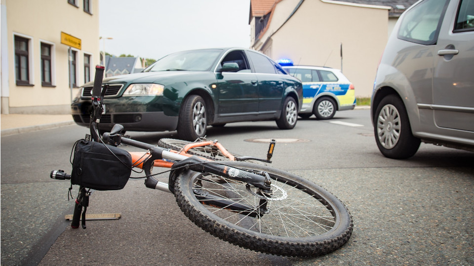 Ein Fahrrad liegt nach einem Unfall mit zwei Fahrzeugen auf der Strasse