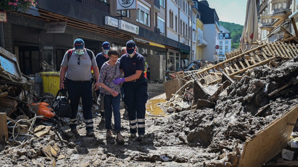 Johanniter helfen einer Frau in einem Katastrophengebiet