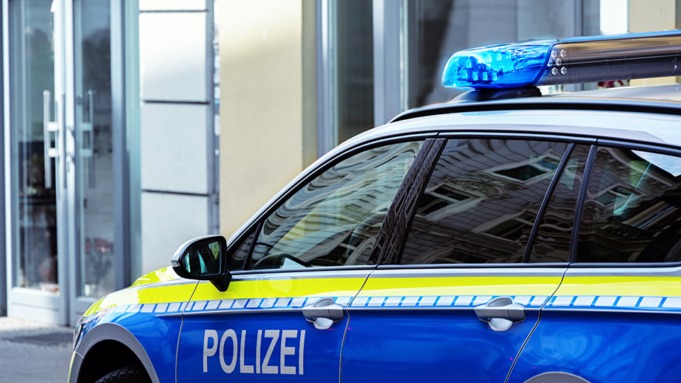 Streifenwagen der Polizei vor Gebäude