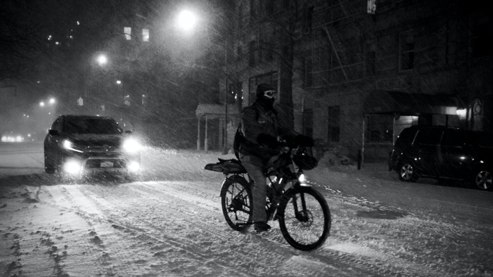 Ein Radfahrer und ein Autofahrer im Winter bei Nacht