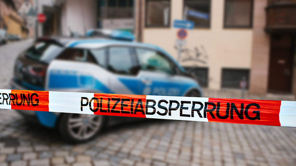 Streifenwagen der Polizei, davor ein "Polizeiabsperrung"-Band