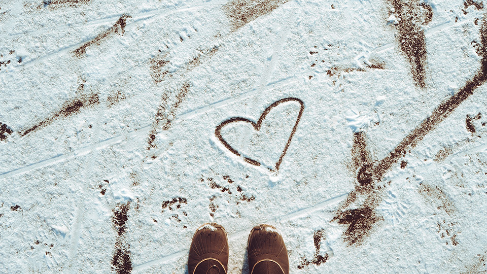 Dankbarkeit: dargestellt durch ein Herz im Schnee, davor sieht man Schuhe, die im Schnee stehen