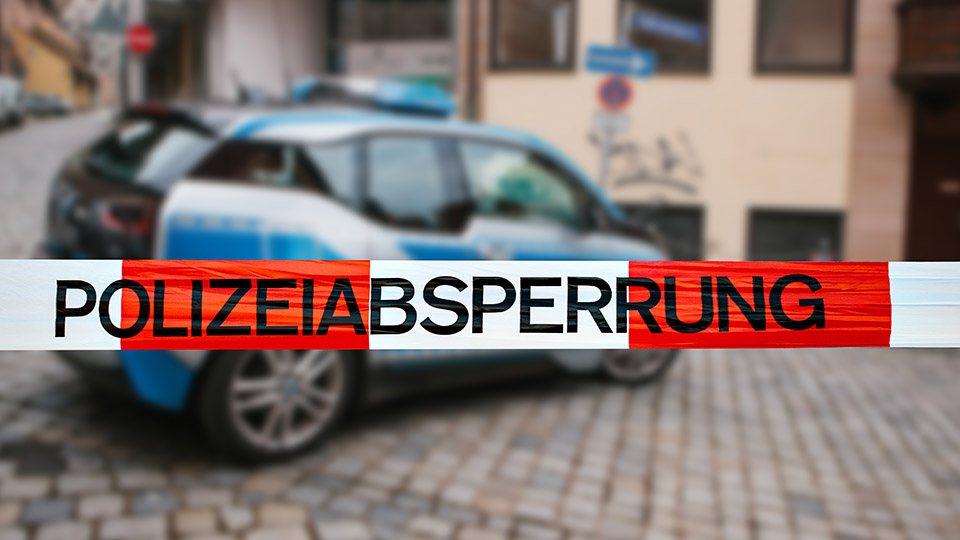 Streifenwagen der Polizei vor einem Gebäude.